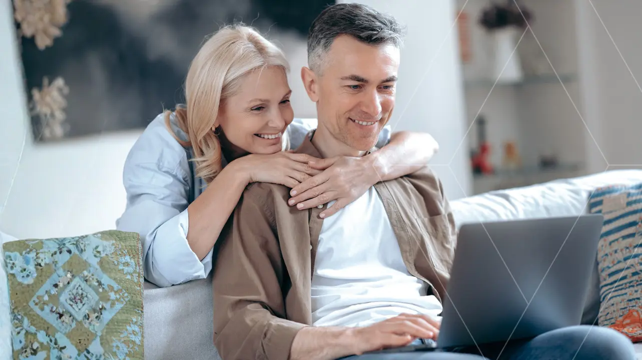 A couple reviewing their early retirement planning strategy on a laptop comfortably at home.