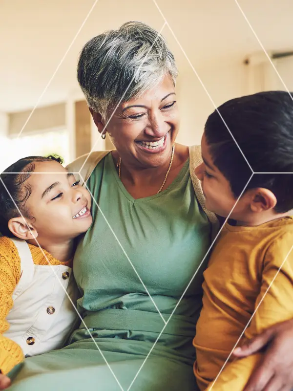 Grandmother hugging her grandchildren at home, illustrating the role of estate planning in protecting family wealth.