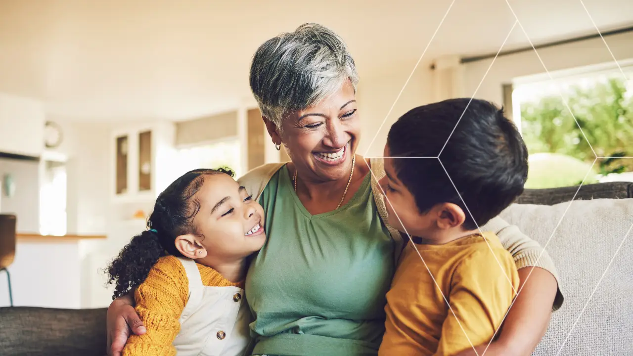 Grandmother hugging her grandchildren at home, illustrating the role of estate planning in protecting family wealth.