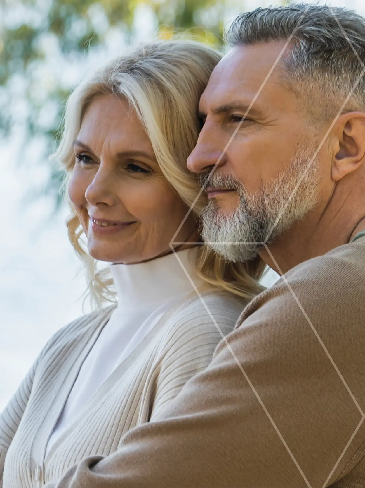 Smiling mature couple outdoors, leaning their heads together in a warm, affectionate portrait.